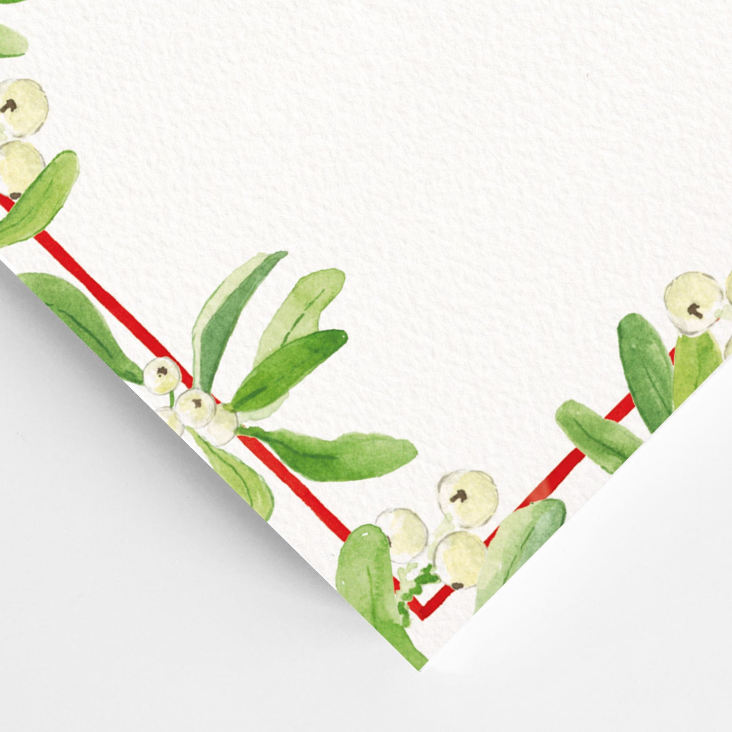 Close-up of the corner of mistletoe festive dinner menu, showcasing the green mistletoe detailing and red border.