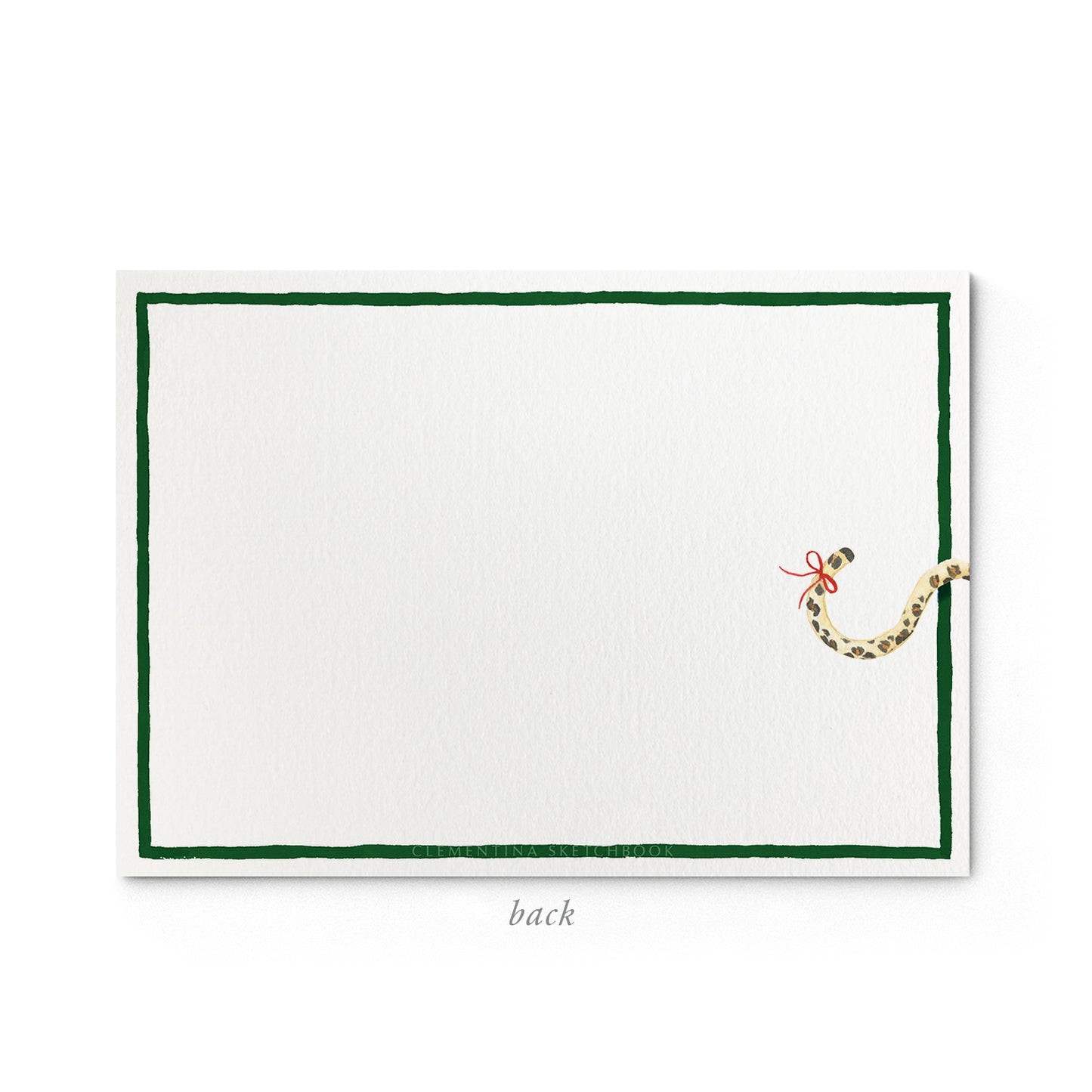 Image shows the back of a Clementina Sketchbook festive leopard print stationery card, with a leopard watercolour design and a dark green border.