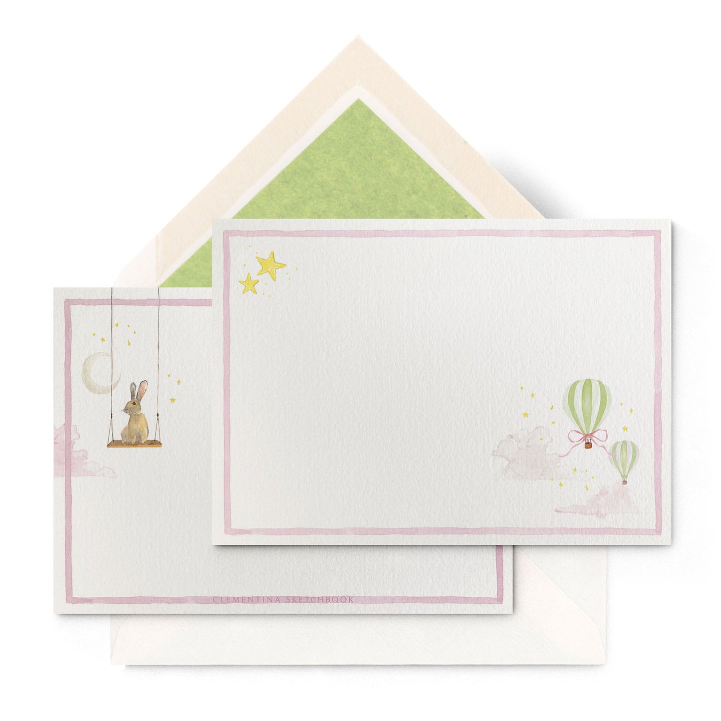 Close-up of Clementina Sketchbook's hot air balloon stationery card with a green border and green tissue envelope.