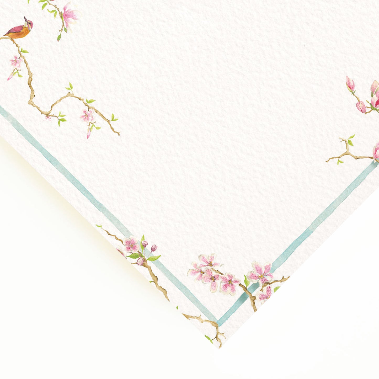 Close-up of the corner of our magnolia wedding dinner menu, showcasing the menu's pastel blue border and hand-painted watercolour designs.