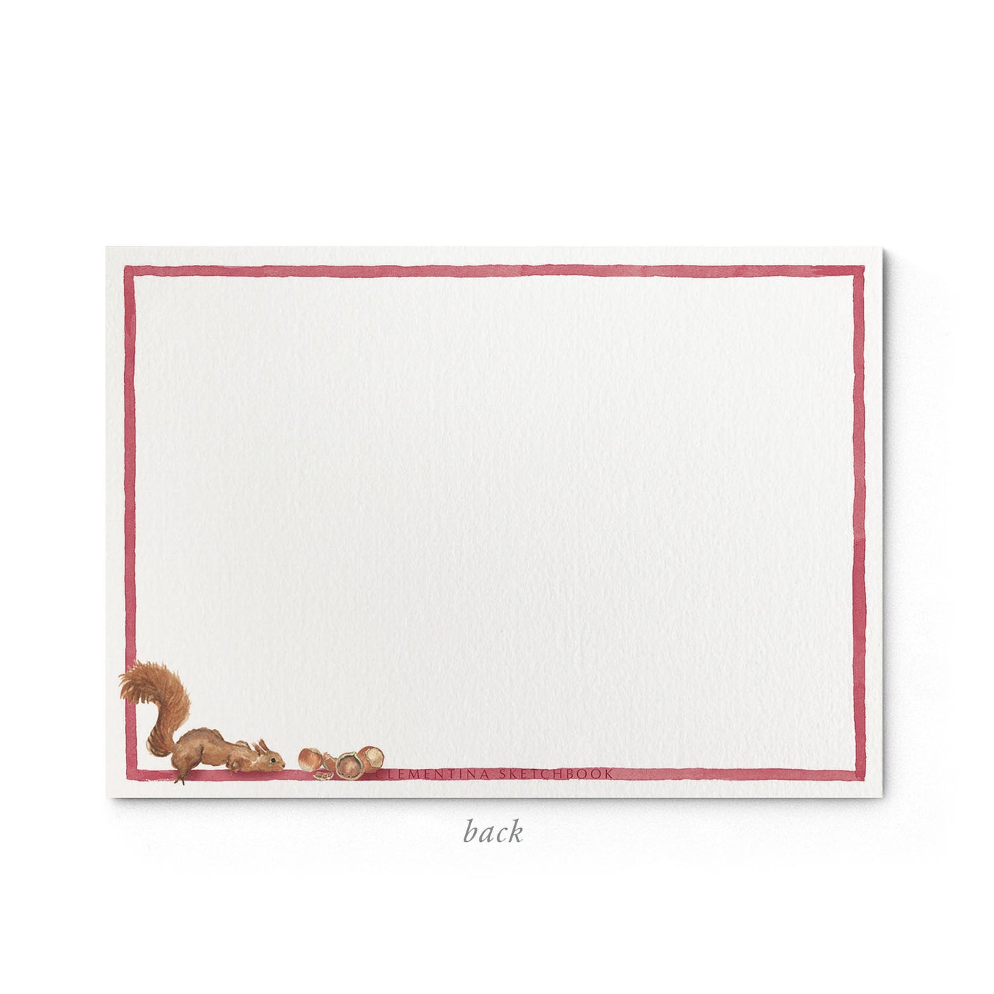 Image shows the back of a Clementina Sketchbook woodland stationery card, with pomegranate and squirrel watercolour design and a red border.