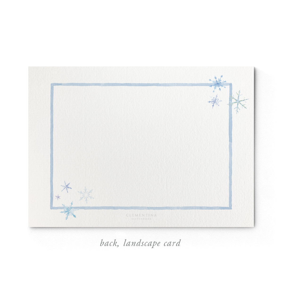 Close-up of the back of Clementina Sketchbook's landscapesnowflake holiday family card with a light blue border, snowflake details and space for personalised text.