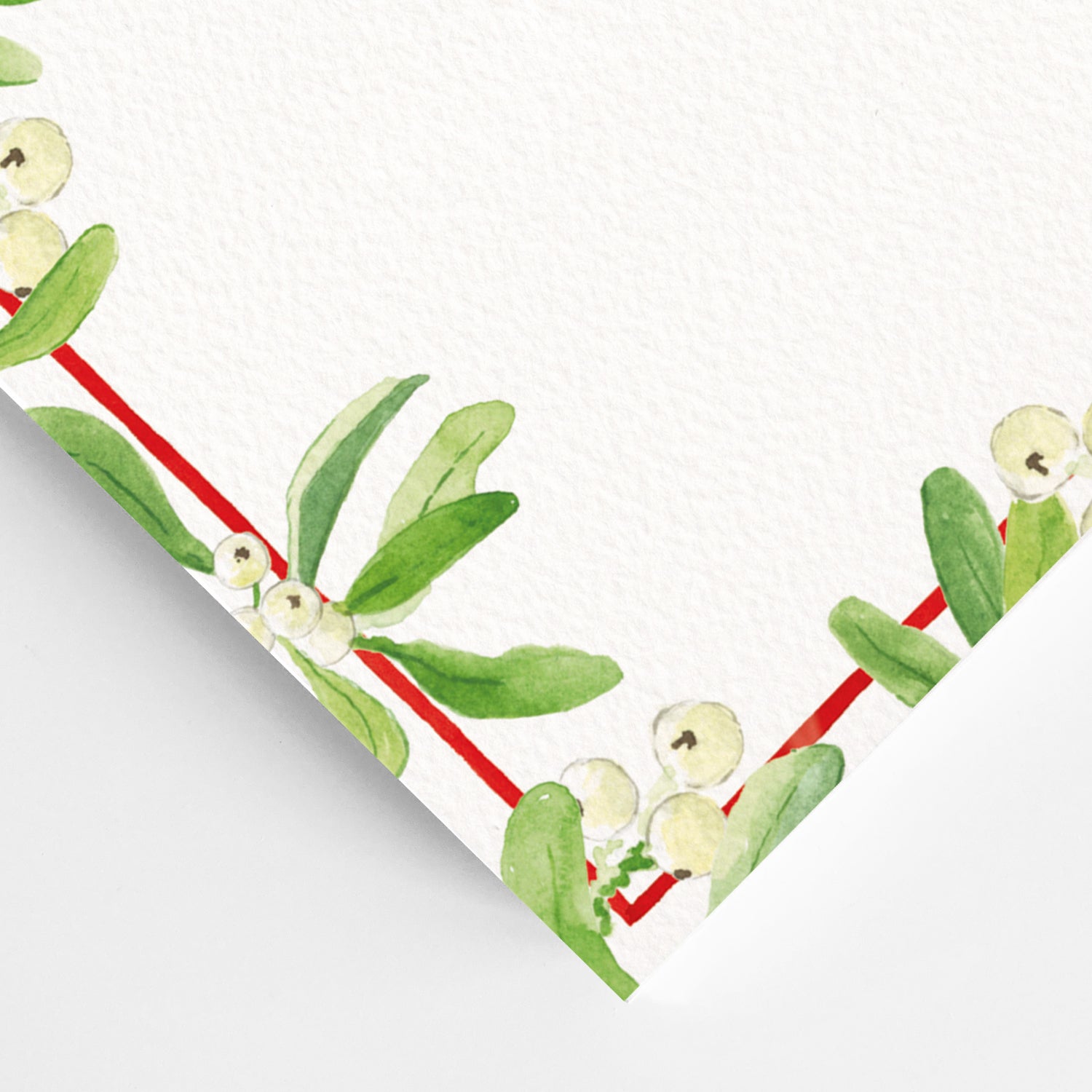 Close-up of the corner of mistletoe festive dinner menu, showcasing the green mistletoe detailing and red border.