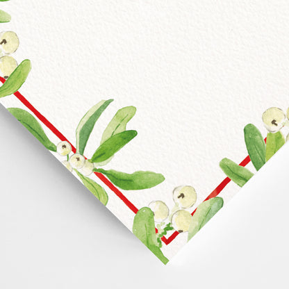 Close-up of the corner of mistletoe festive dinner menu, showcasing the green mistletoe detailing and red border.