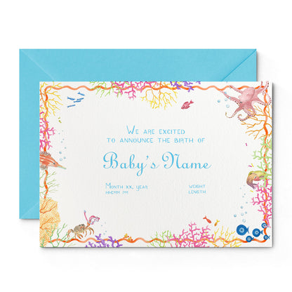 Image of Clementina Sketchbook's coral reef printed birth announcement, with a multicoloured coral border, blue personalised text and a blue envelope.