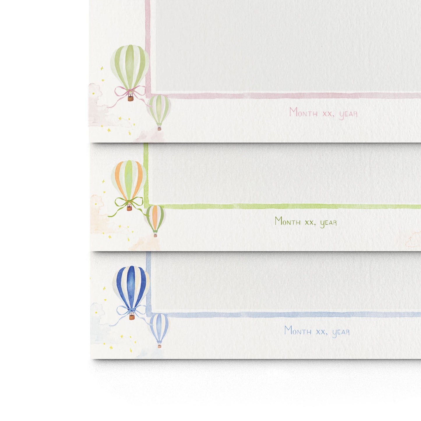 Close-up of the three different variations of Clementina Sketchbook's hot air balloon printed birth announcements layered on top of each other, showcasing the watercolour designs.