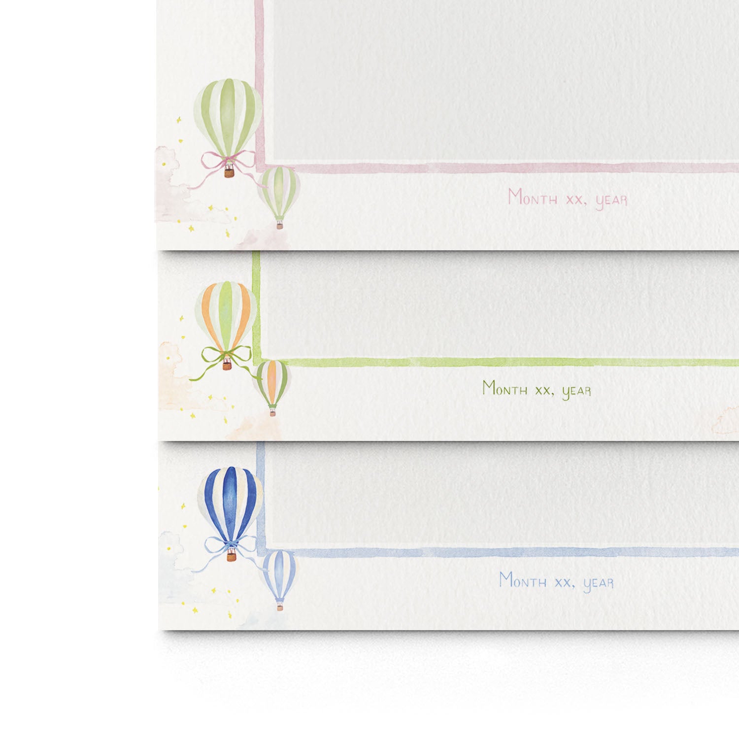 Close-up of the three different variations of Clementina Sketchbook's hot air balloon printed birth announcements layered on top of each other, showcasing the watercolour designs.