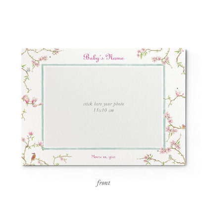 Image of the front of Clementina Sketchbook's magnolia printed birth announcement with a floral border and space for a baby photo to be stuck.