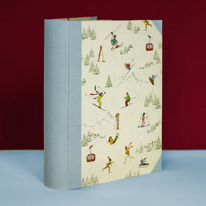 Light blue Mountain Activities family photo album with skiing scenes, handmade in Italy, part of Clementina’s personalised photo albums.