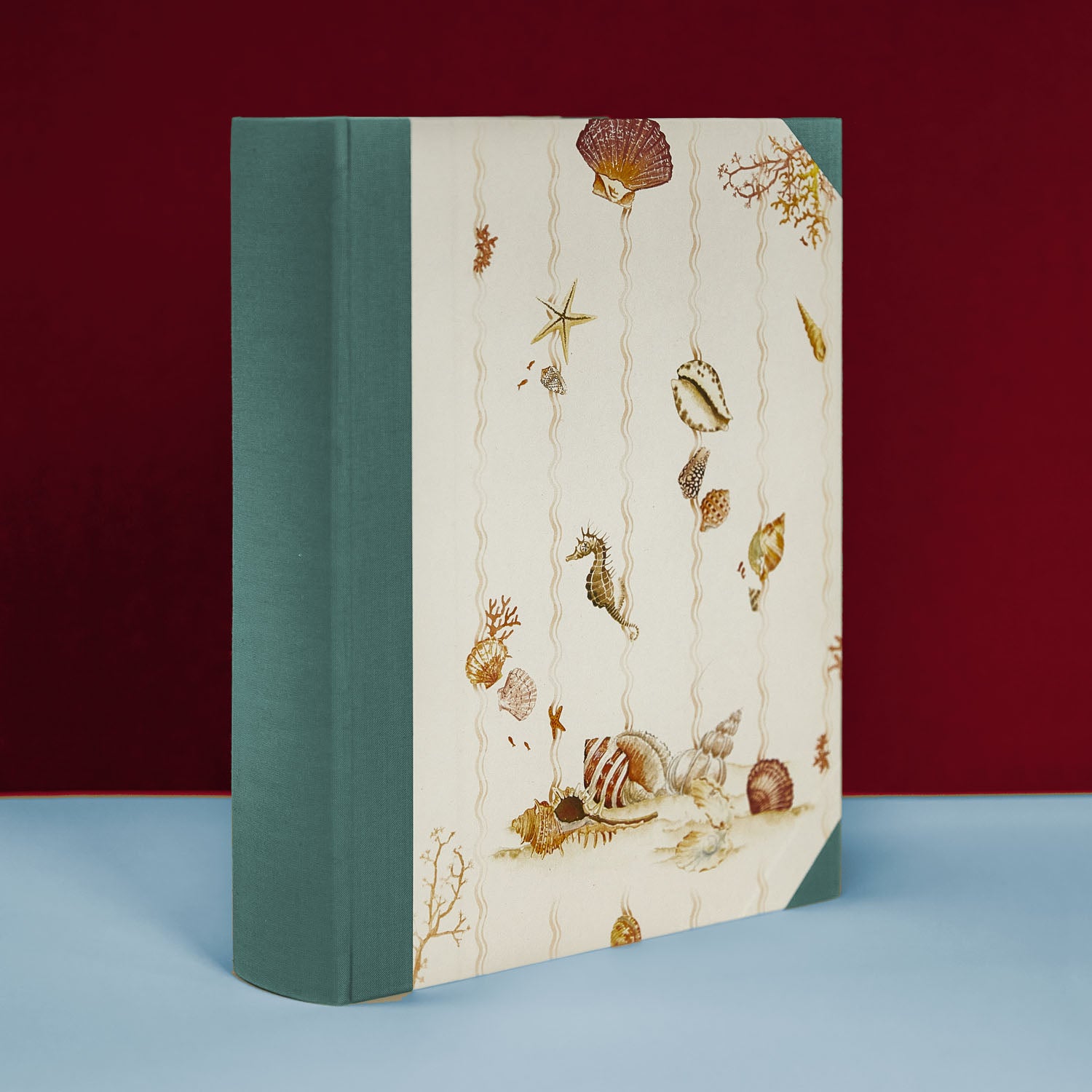 Turquoise Shells on Shells album standing upright, personalised family photo album and holiday photo album, handmade in Italy.