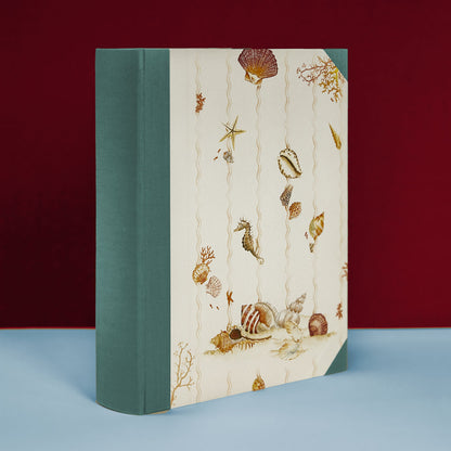 Turquoise Shells on Shells album standing upright, personalised family photo album and holiday photo album, handmade in Italy.