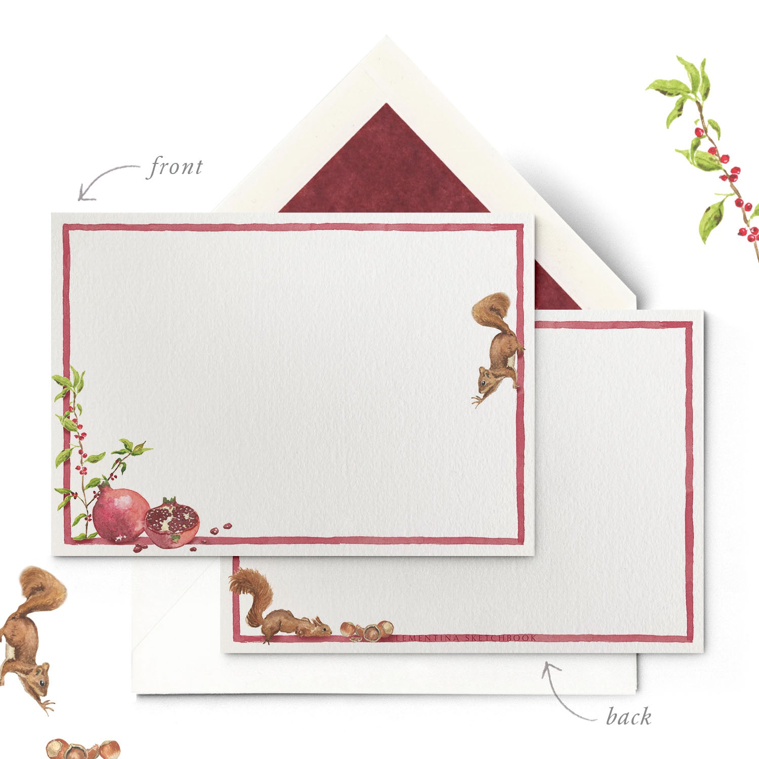 Close-up of a Clementina Sketchbook woodland stationery card, with pomegranate and squirrel watercolour design, a red border and a red tissue envelope.